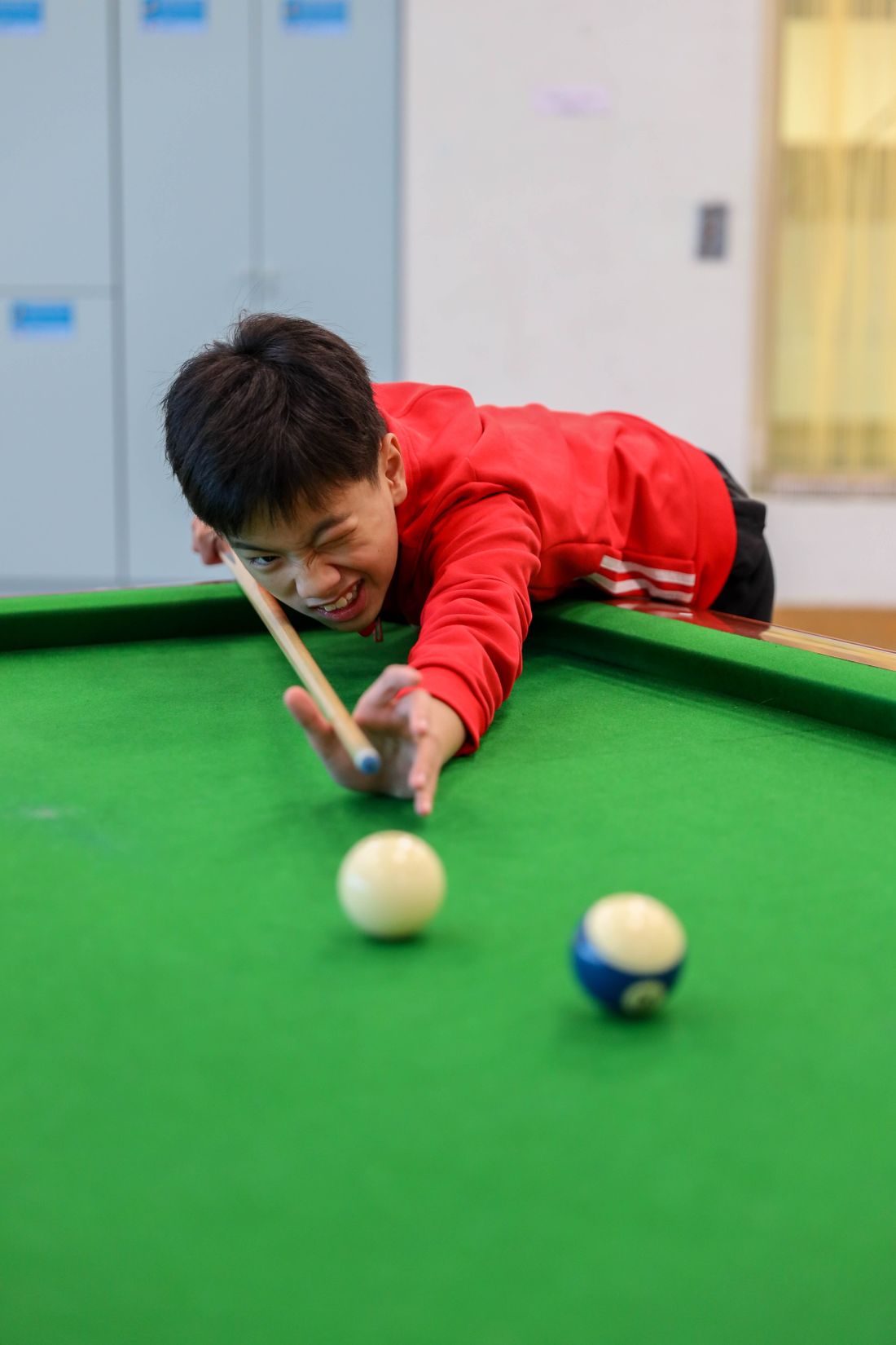 A young person playing pool at the centre